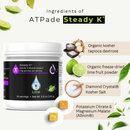 A white tub of ATPade Steady K+ dietary supplement on a light cream background, surrounded by ingredient callouts including lime, tapioca dextrose, freeze-dried lime powder, kosher salt, and potassium citrate/magnesium malate.